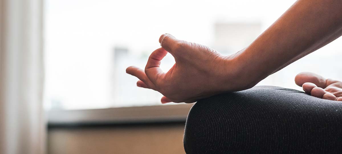 Close up of knee and hand and thumb making circle