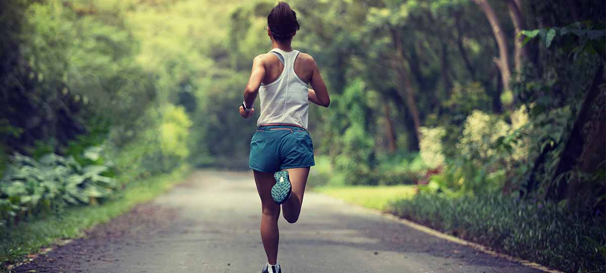 Runner from behind running down middle of tree-lined road